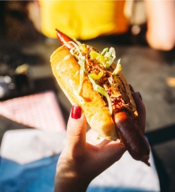 Daily Dog medewerker serveert hotdog aan klant
